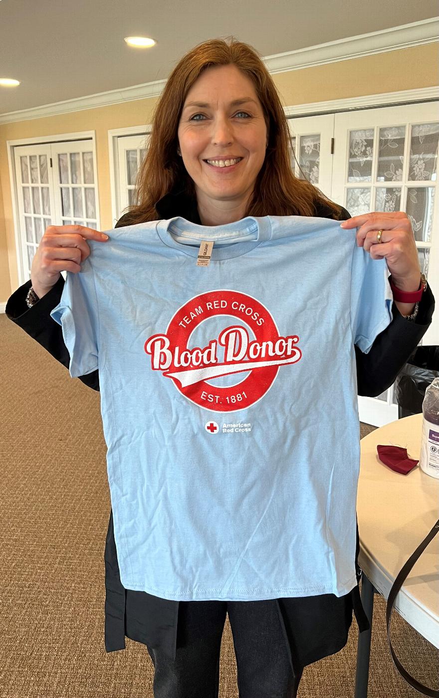 Carmen Timm, Red Cross Area Blood Drive Director shows off one of the Donor T-Shirt presented to the first 25 donors