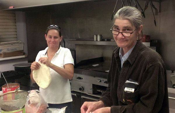 PEY Jessie Sutfin (R) and volunteer chef Dawn Burton (L) in the kitchen making pies for another Pizza Night in the lounge.