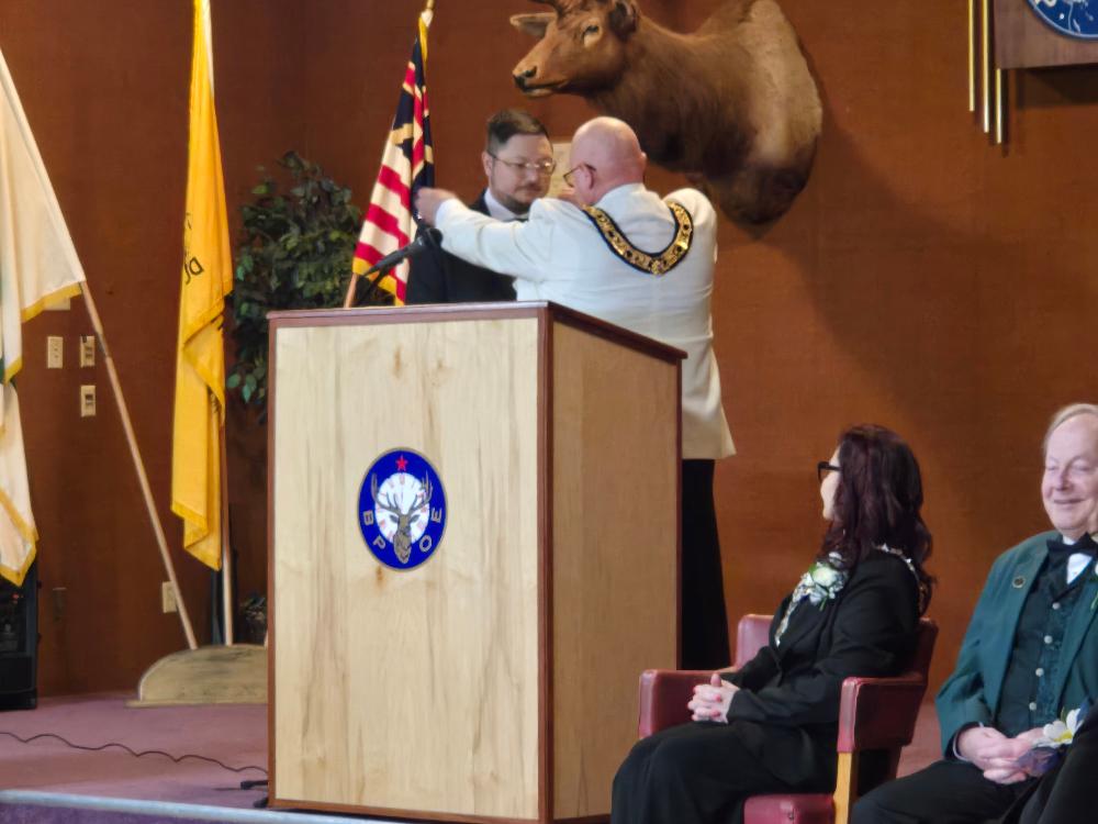 Exalted Ruler Chris Beck receives the jewels of office from Past District Deputy Lanny Schulze.