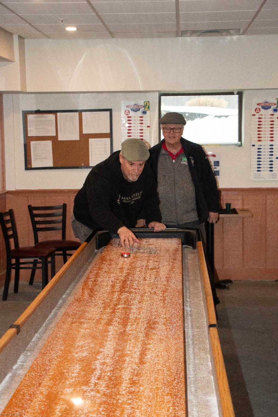 Couple of Mansfield Members  enjoying a game of  Shuffleboard tables