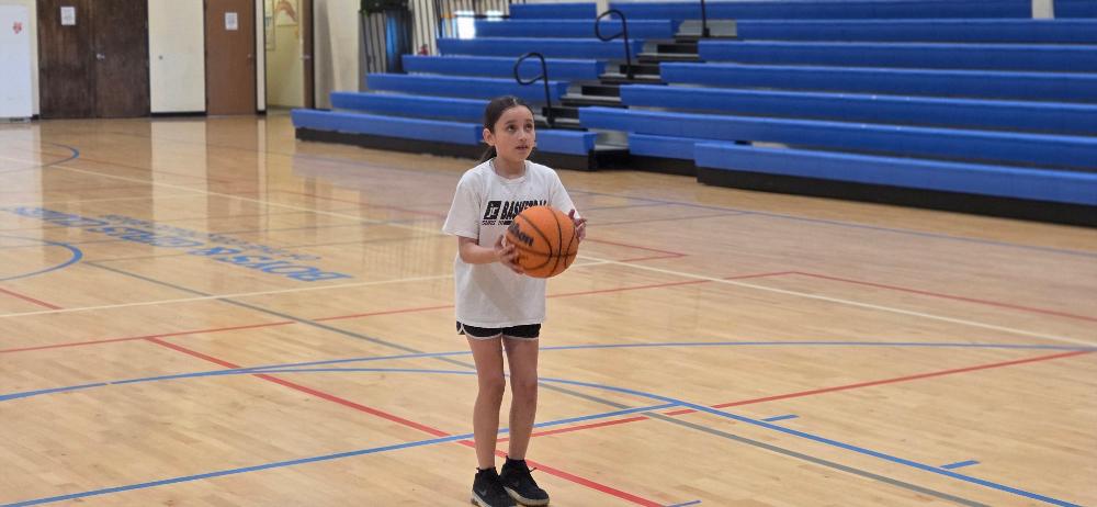 Hoop Shoot participant 2025. Concentrating hard to get that perfect shot!