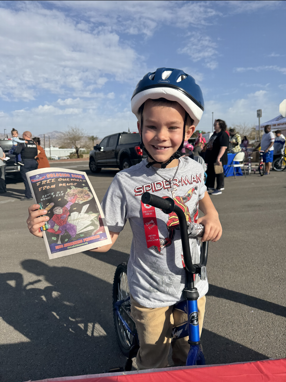 BHC Police Bike Rodeo attendee and Drug Awareness booth visitor showing his color book he got at the Elks drug awareness booth